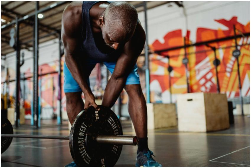 Athletic man lifting weights in a modern gym with