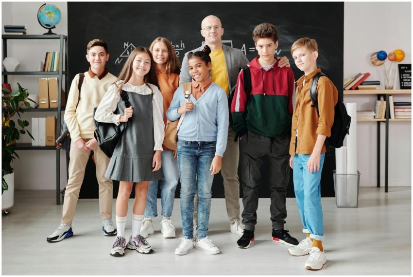 Group of diverse teenagers posing with their teach