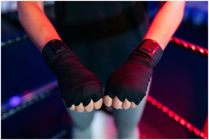 Female boxer wearing smart gloves in a gym, showca