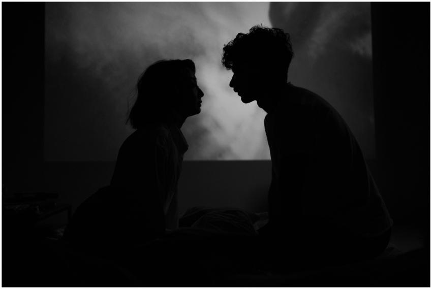 A romantic silhouette of a couple facing each othe