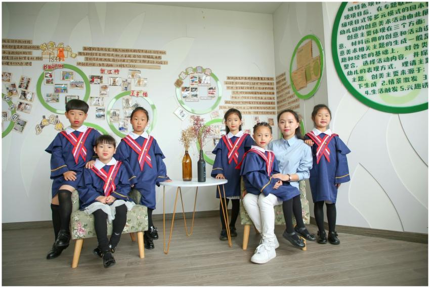 Group of children in academic gowns with teacher i