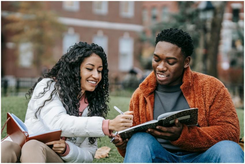 Happy college students studying together on a camp