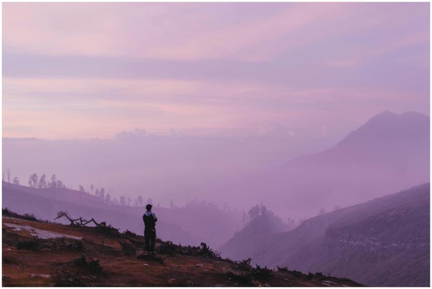 Silhouette of a person at dusk overlooking beautif