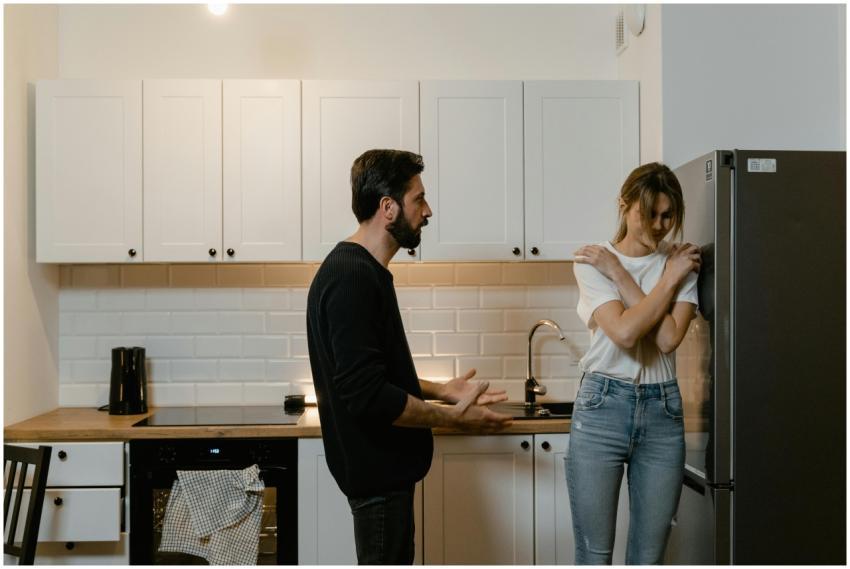 A couple argues in a modern kitchen, illustrating