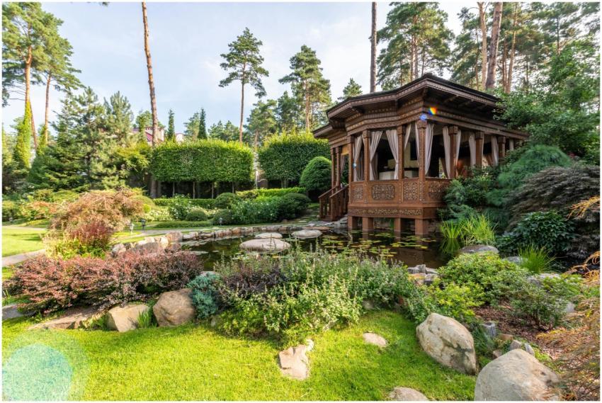 A peaceful wooden gazebo in a vibrant garden featu