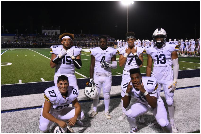 A group of high school football players posing on