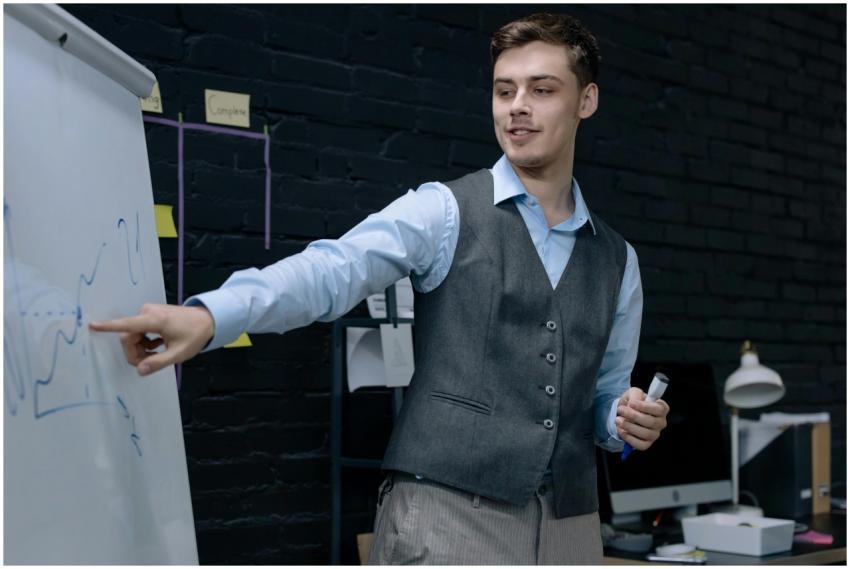 Businessman presenting data on a whiteboard in a c