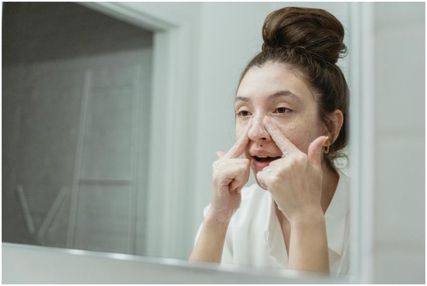 A young woman applies skincare in front of a bathr