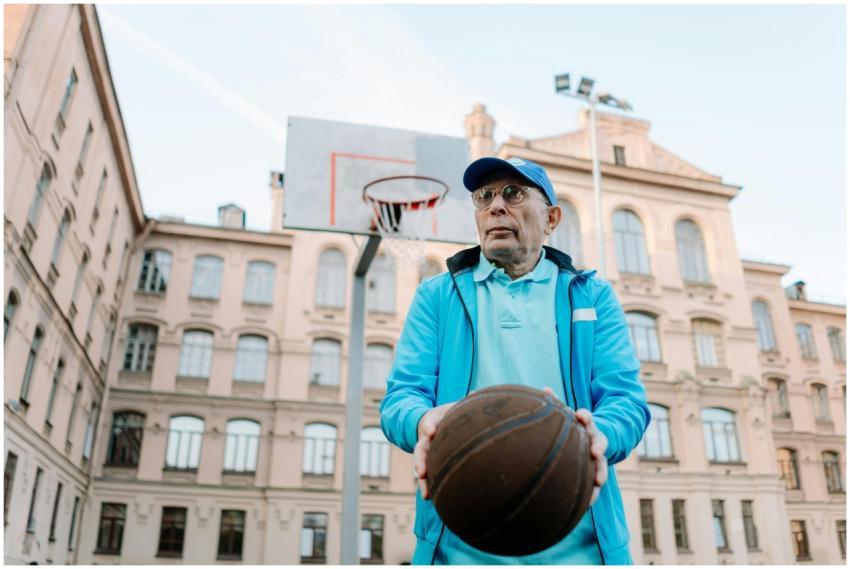 Elderly man playing basketball on an outdoor court