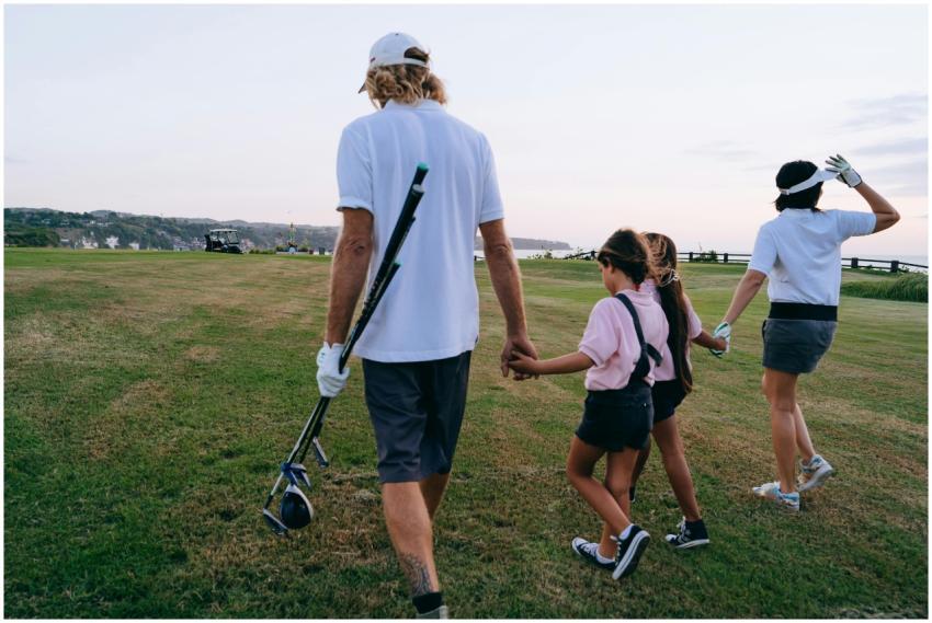 Family with children walking on a golf course enjo