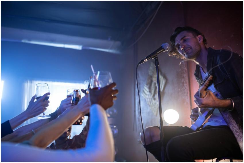 Musician performing live on stage in a lively nigh