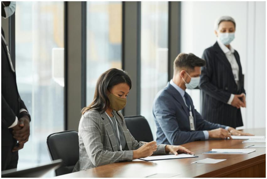 Professionals in face masks having a business meet