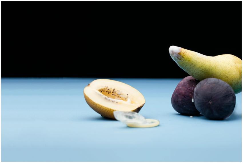 Close-up of pear and figs on blue surface with bla