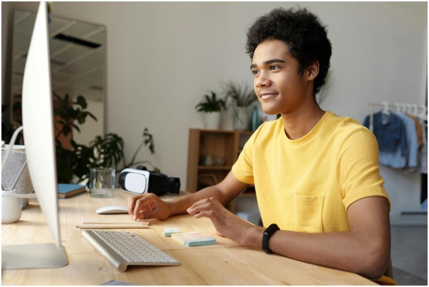 Teenager smiling while studying online at home. Mo