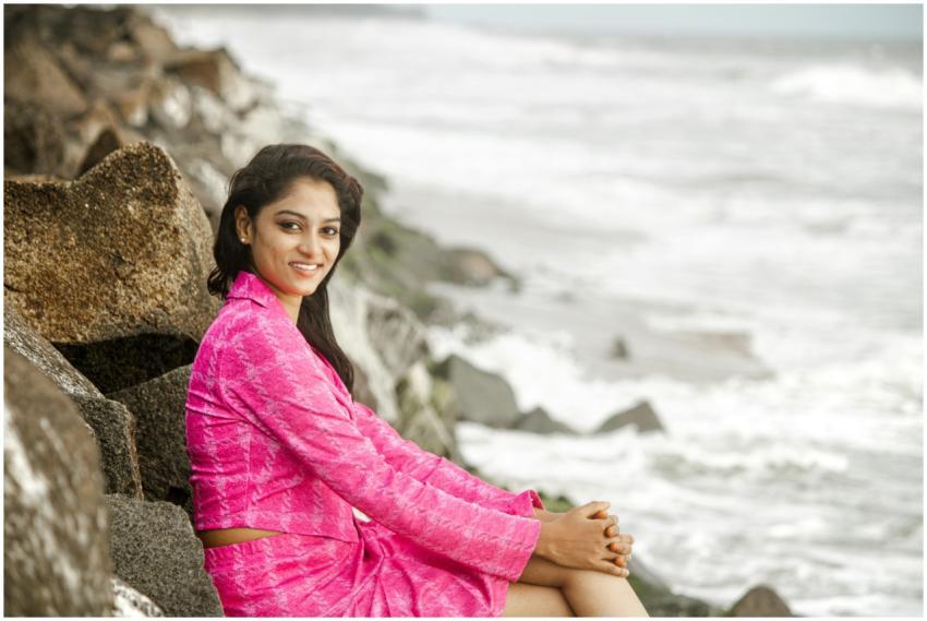 Smiling woman in a vibrant pink outfit sitting on