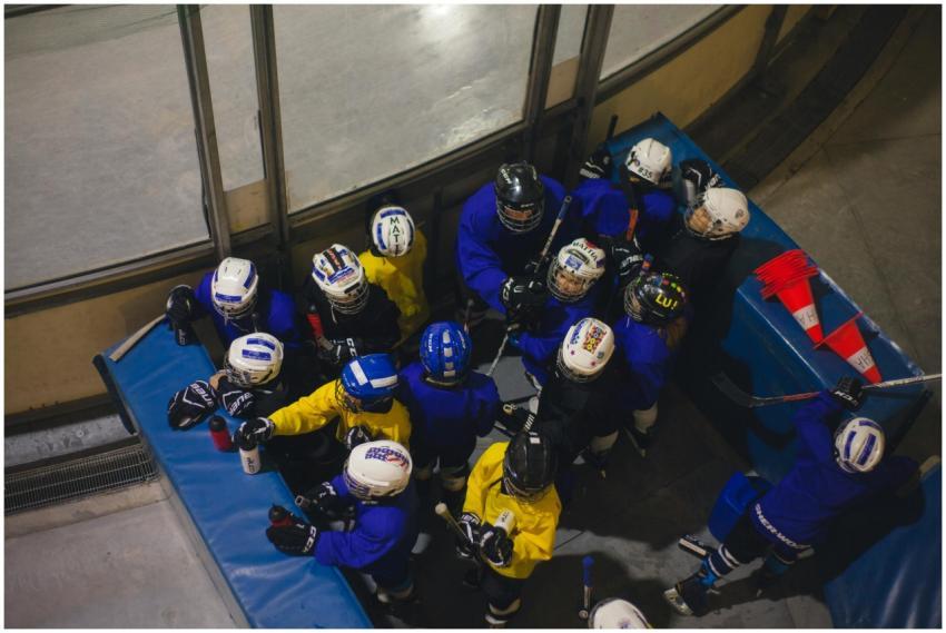 Top view of youth ice hockey team huddling indoors
