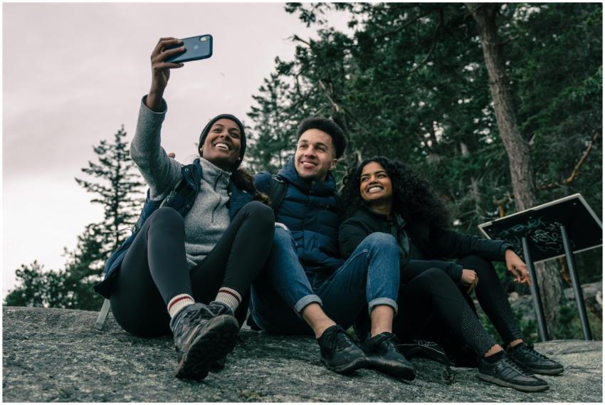 Three friends pose for a fun selfie while hiking i