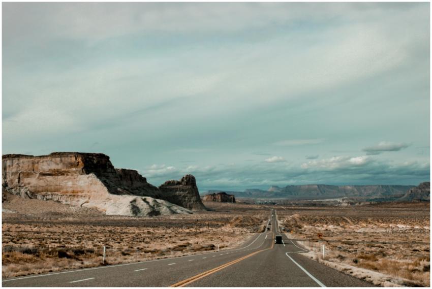 A long, straight highway through the desert landsc