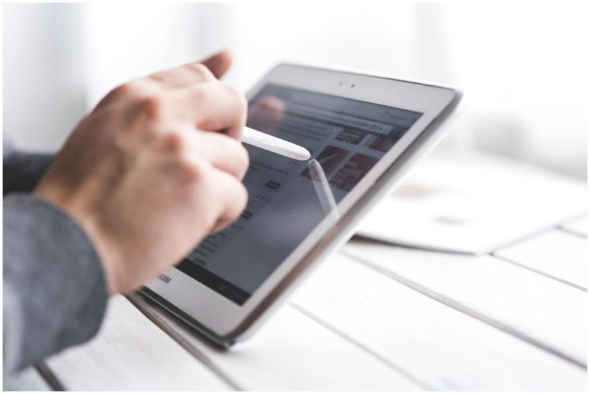 Close-up of a hand using a stylus on a tablet, sho