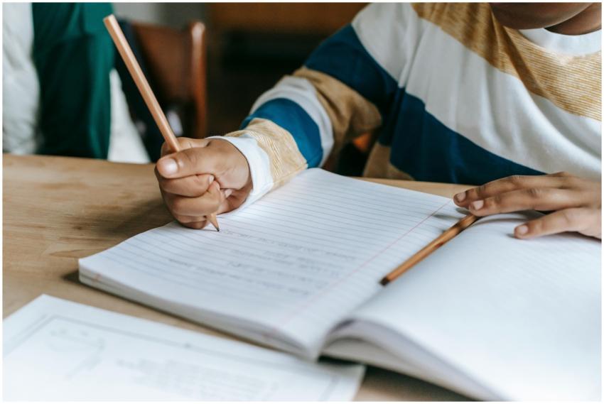Young student concentrating on writing in a classr