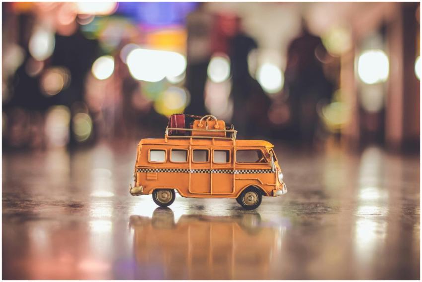 Close-up of a toy yellow campervan with luggage on