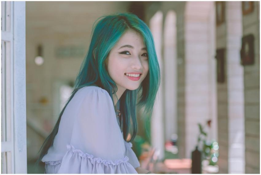 Beautiful young woman with vibrant green hair smil