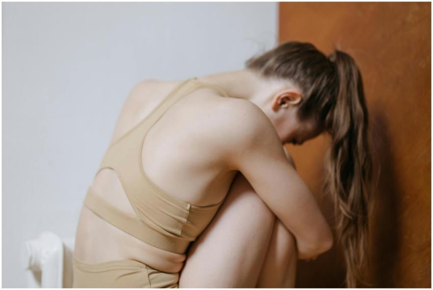 A contemplative young woman in beige sportswear si