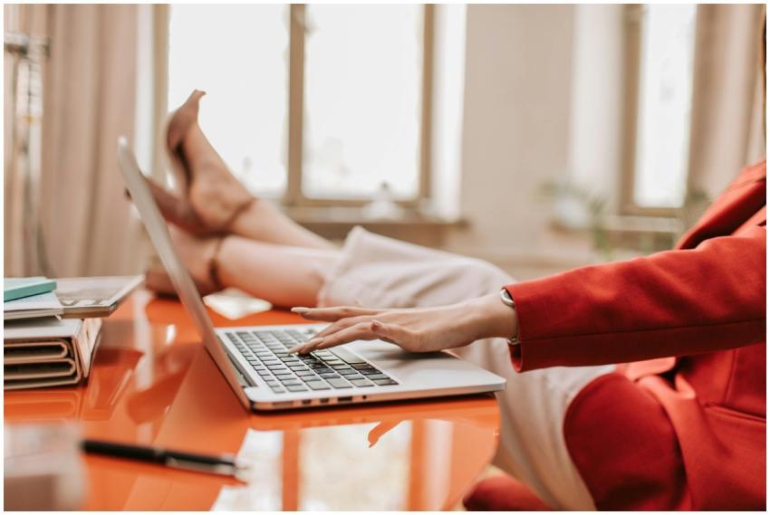 Businesswoman in red blazer working on laptop at d