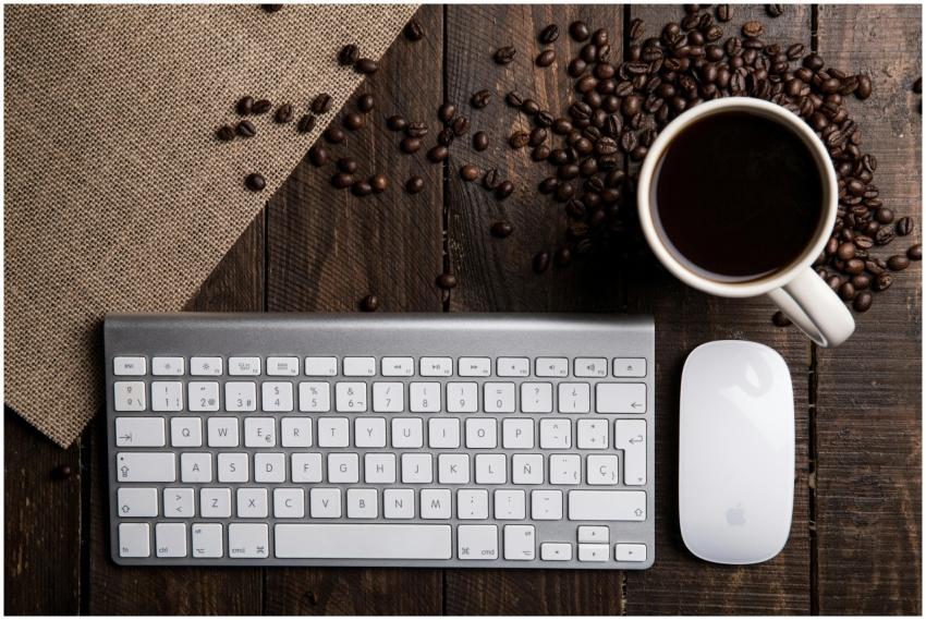 Top view of a coffee cup with keyboard and mouse o
