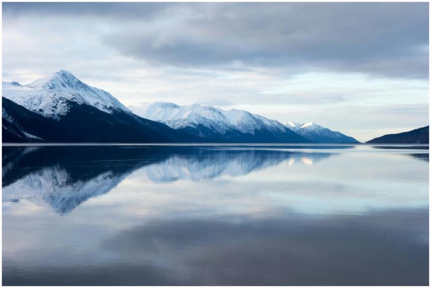 Beautiful snow-capped mountains reflected in a cal