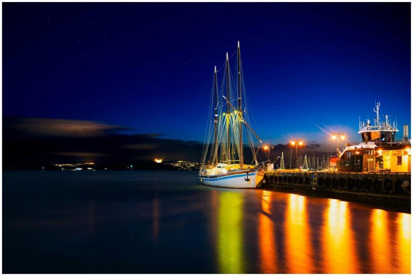 A beautifully lit sailboat docked in the Oslo harb