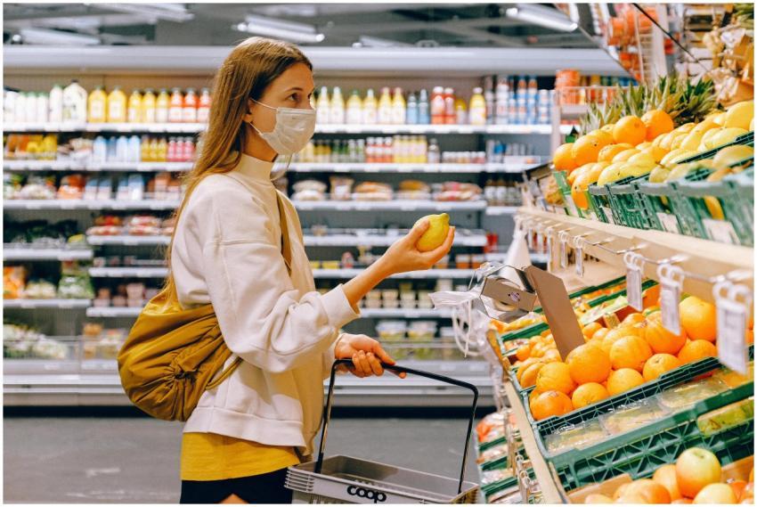 A woman wearing a face mask shops for fruits in a