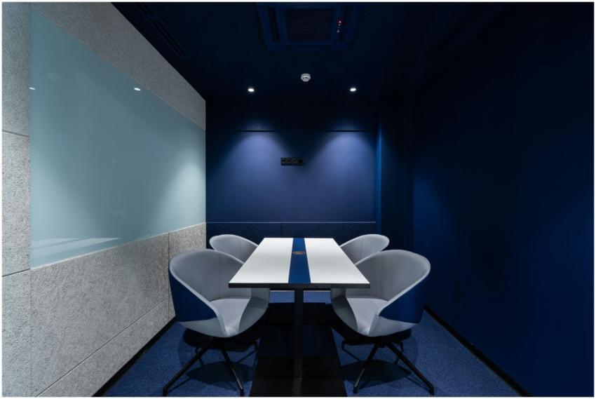 Comfortable chairs placed on carpet at long white