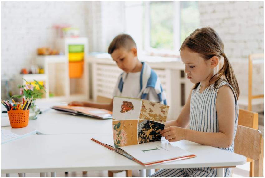 Two children reading books at a bright indoor clas