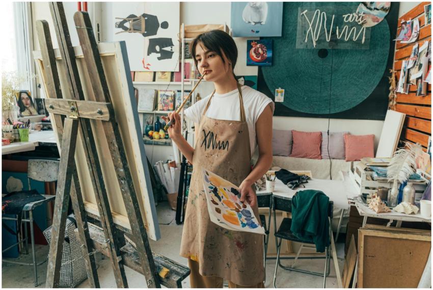 A female artist in a studio, pondering her artwork