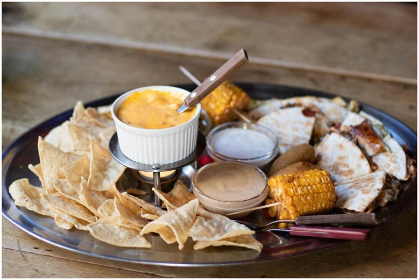 Mexican platter featuring cheese dip, corn, quesad