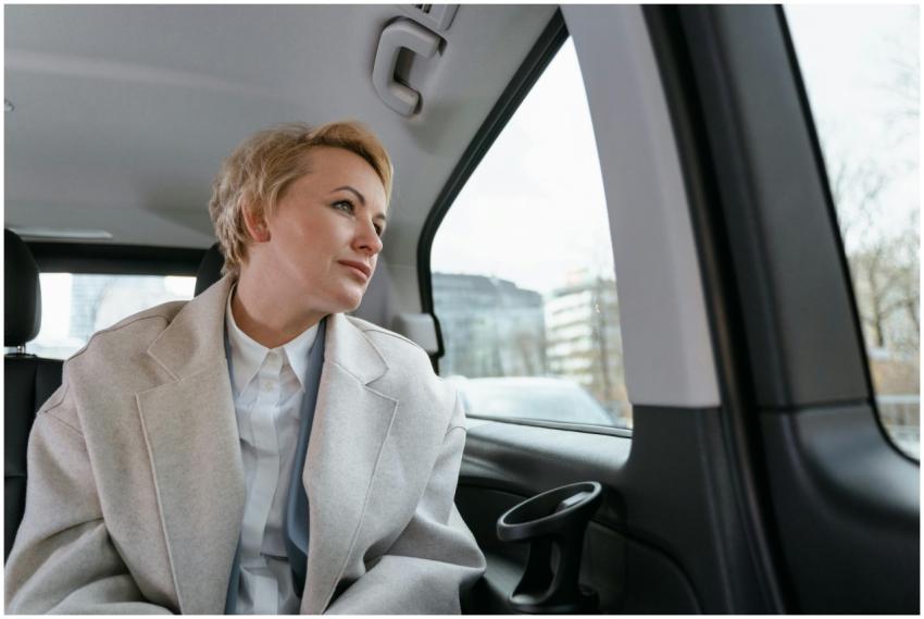 Businesswoman in a car, gazing thoughtfully out th