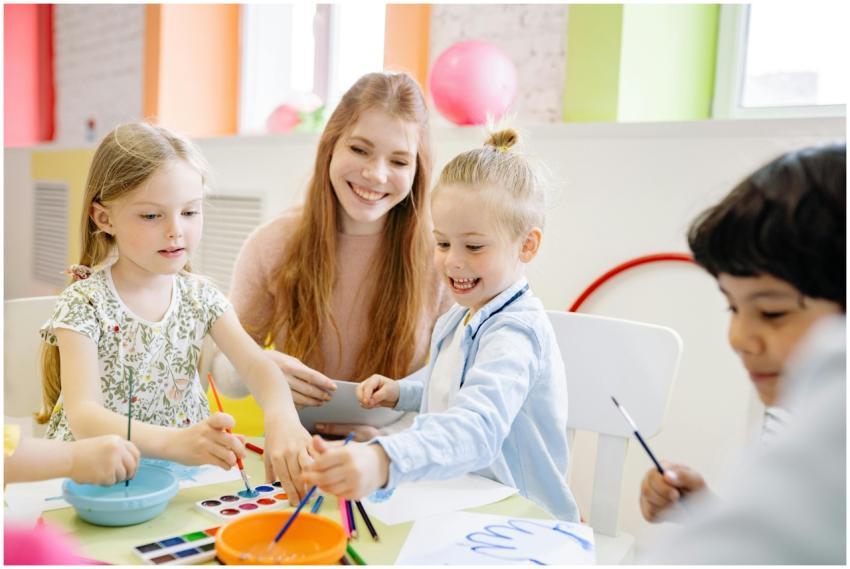 Young children enjoy painting with a teacher in a