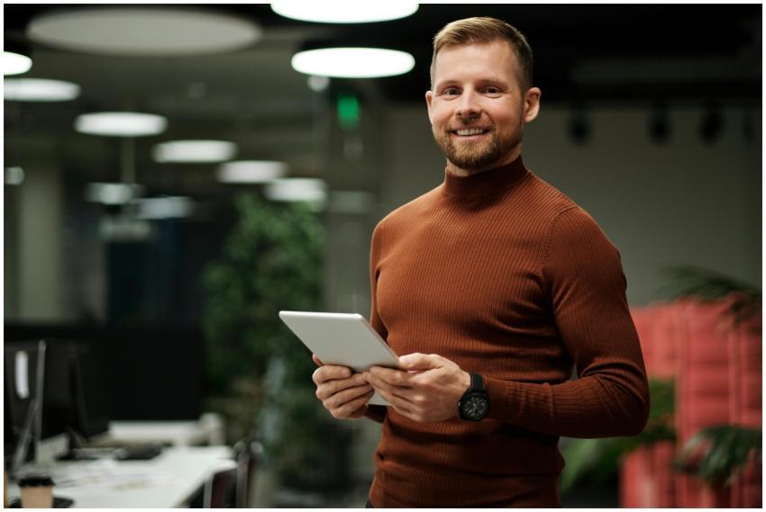 Confident man with tablet in a modern, dimly lit o