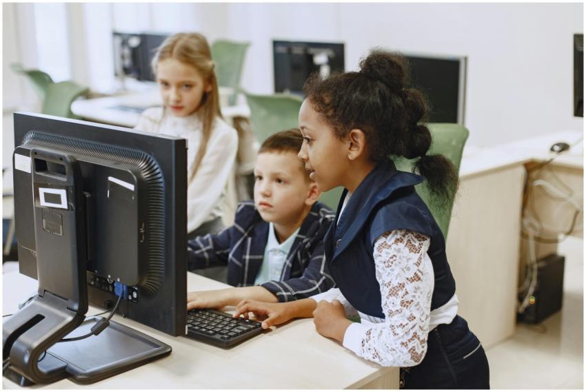 Diverse group of children working together on comp