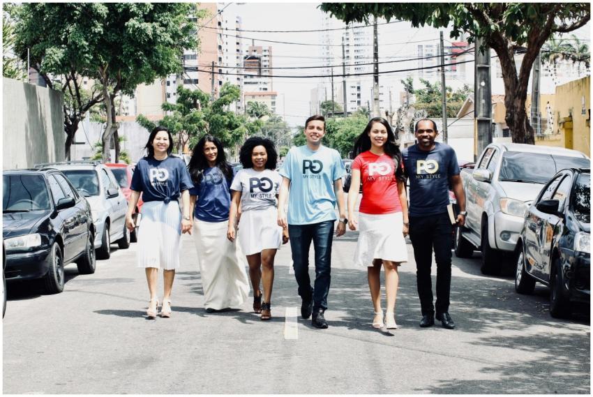Six adults happily strolling on an urban street, s