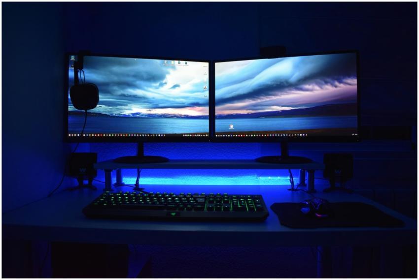 Dual monitors with blue lighting on a gaming desk