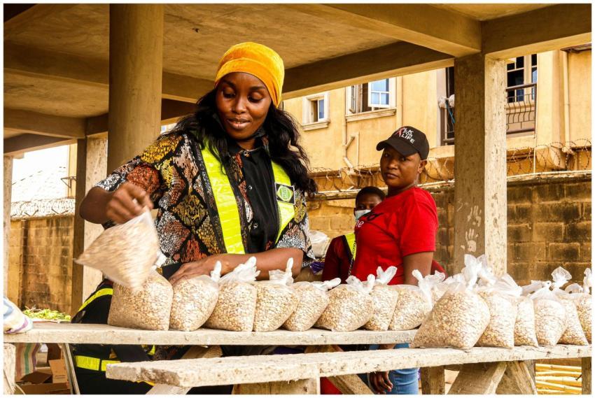 Two women selling bags of cereal at an outdoor mar