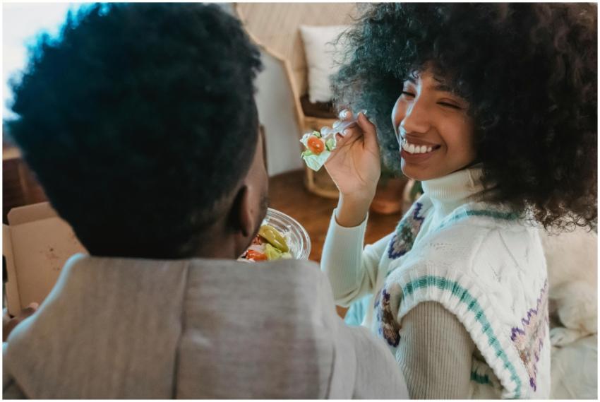 Happy crop African American caring girlfriend feed