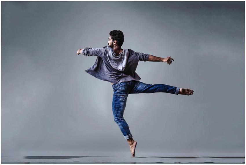 A male dancer executing a high jump in a studio se