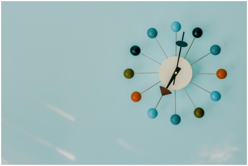 Close-up of a colorful modern wall clock on a blue
