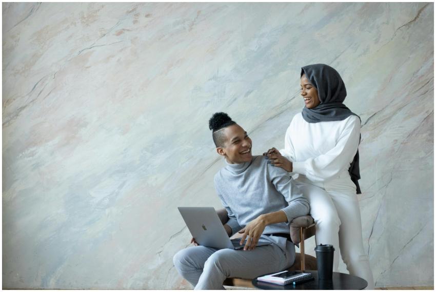 Joyful young ethnic friends in casual clothes usin