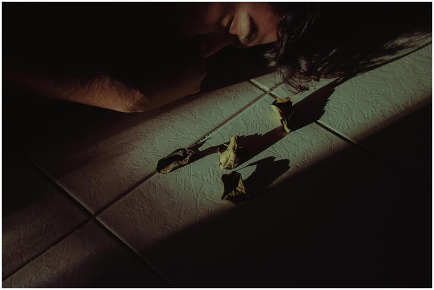 A dramatic shot of a person lying on the floor sur