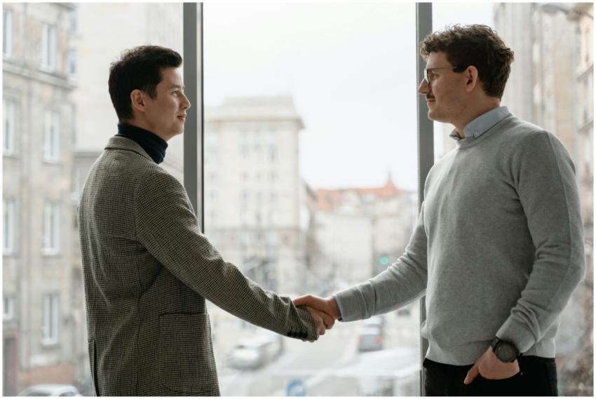 Two businessmen shaking hands in a modern office,