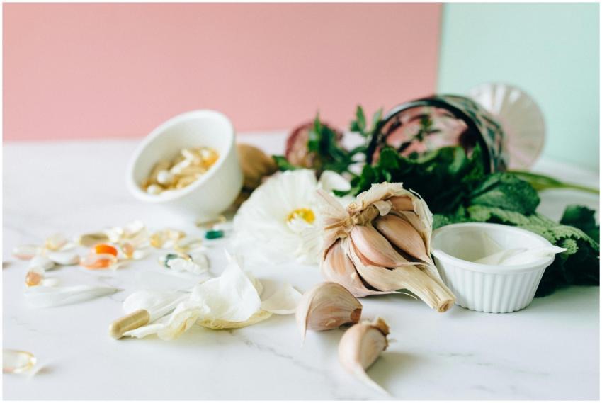 Flat lay of garlic, supplements, and herbs showcas